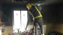 Un bombero del parque de Chantada revisa la cocina tras la extinci�n del fuego