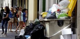 Varias j�venes pasan por delante de basura acumulada en el centro durante la huelga de la semana pasada.