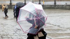 Una mujer se protege de la lluvia con un paraguas en Santiago