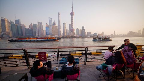 Gente tomando caf� en una terraza, con el �skyline� de Shangh�i al fondo.