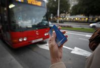 Una usuaria espera la llegada del bus con su tarjeta Millennium en la mano. 