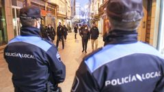 Dos polic�as locales de Ferrol patrullan las calles del centro, durante las fiestas de Navidad