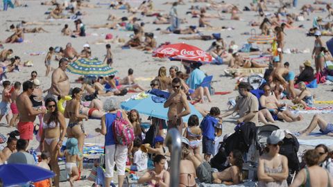 Gente tomando el sol y ba��ndose en la playa de Riazor, en A Coru�a, en un d�a de mucho calor