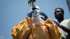 Un higienista se coloca el equipo de protecci�n individual (EPI) antes de entrar a un Centro de Salud en Mongbwalu, en la provincia de Ituri