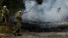 En una imagen de archivo, agentes de las brigadas forestales de la Xunta extinguen un fuego en Ames