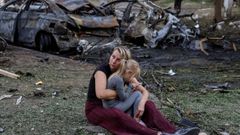 Una mujer y su hija junto al lugar de un bombardeo en Borispil, Ucrania.
