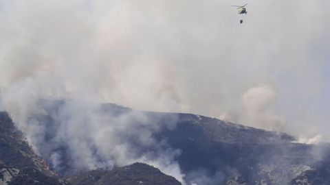 Un helicoptero trabaja en las labores de extinci�n del incendio forestal declarado en Belmonte. Asturias
