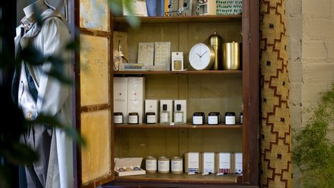 En la tienda hay una selección de productos, entre ellos perfumes y velas