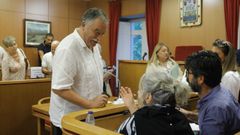 El regidor de Oleiros conversa con los concejales socialistas al inicio de un pleno.