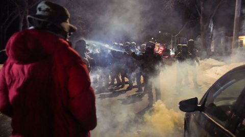 Un agente roc�a un agente qu�mico contra un manifestante la noche del jueves en Mine�polis.