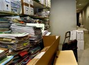 Archivadores con expedientes del 2008 al 2013 apilados en los pasillos por falta de sitio.