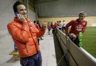 �scar D�az, hablando por tel�fono, junto a Quique Seti�n antes de un partido de f�tbol indoor.