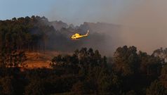 Helic�ptero sobrevolando la zona afectada por el fuego en Ra�obre, Arteixo