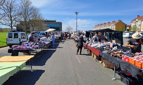 Imagen de unas calles del mercadillo de Salgueiriños, cuyos puestos se colocan a lo largo y ancho del párquing. Hay algunos con la ropa nueva y conlgada, mientras que otros extienden sus prendas encima de una mesa.