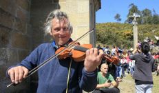 Un violinista toca bajo el sol de la primavera. 
