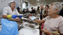 Una clienta mostrndole el mvil a una pescadera de la plaza de Vilagarca de Arousa para beneficiarse del descuento del Bono Peixe