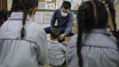 Un profesor pone una mascarilla a un ni�o de Infantil en el CEIP Raquel Camacho de A Coru�a