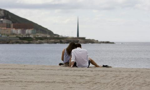Una pareja disfrutando del mar y la calma en la playa del Orz�n en A Coru�a. 
