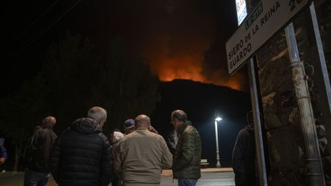 Varios vecinos de Boca de Hurgano (Len) observan el avance de uno de los fuegos que rodean a la localidad.