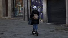 Una persona circulando con un patinete por una zona peatonal, en imagen de archivo.