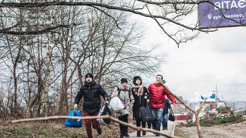 Una familia corre ante el bombardeo en Irpn