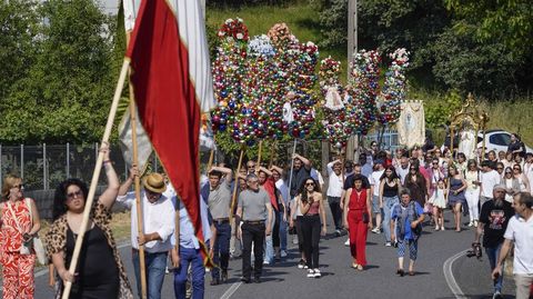 Estandartes y ramos con bolas de colores acompañan a la virgen en la procesión.