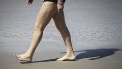 Ba�ista en la playa del Orzan caminando descalzos