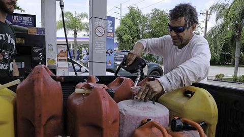 Un residente local llena bidones de gasolina.