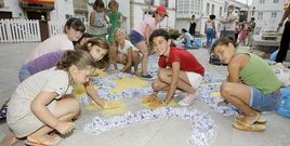 Ni�os y adultos elaborando ayer las alfombras florales de San Cibrao.