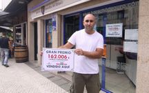 Carlos V�zquez muestra el cartel con el premio. 