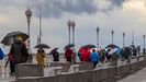 Varias personas caminan junto a la playa de San Lorenzo, en Gij�n, durante el temporal