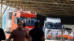 Trabajadores se re�nen mientras llegan camiones con ayuda al lado palestino de la frontera con Egipto.