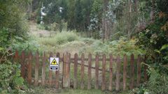 Cartel de advertencia en el acceso colocado por los okupas, con la casa al fondo