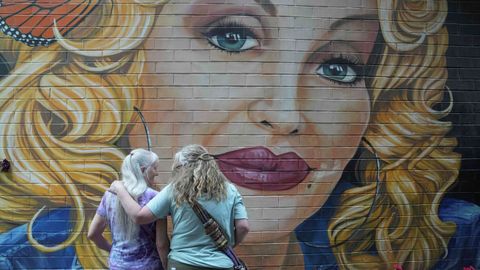 Dos mujeres ante un mural que homenajea a Dolly Parton en Knoxville (Tennessee, Estados Unidos)