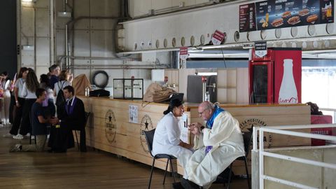 Un sacerdote confiesa a una persona antes de la vigilia de oraci�n con el Papa Le�n XIV, en el Estadio Ol�mpico Llu�s Companys.