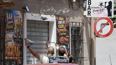 Agentes de polic�a precintan el local donde un hombre de 62 a�os ha matado a un joven de 20 a�os en Valencia.