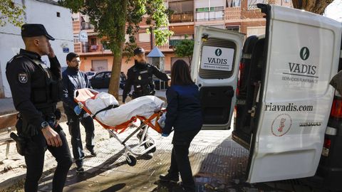 Operarios del ret�n f�nebre trasladan el cad�ver de uno de las tres v�ctimas del incendio de Valencia