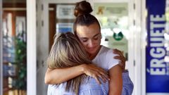 Carlota, de espaldas, con Roco Iglesias, trabajadora social. 