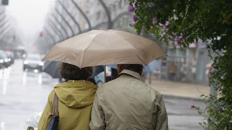 -Una pareja pasea por la Plaza de Europa, en Gij�n, este mi�rcoles en una jornada lluviosa