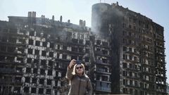 Una mujer se toma un selfi frente al edificio incendiado en el barrio de Campanar en Valencia.
