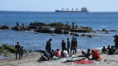 Varias personas migrantes este mi�rcoles en la playa ceut� del Trampol�n.