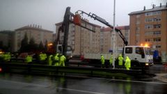 Los operarios, retirando el cartel de Alfonso Molina