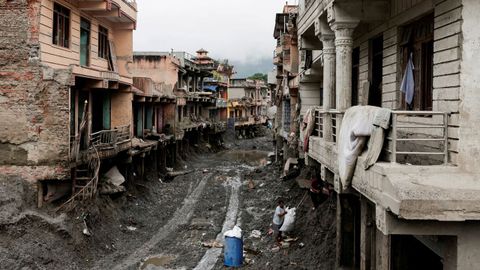Varias personas buscan pertenencias en la zona de Nepal afectada en septiembre por la inundaci&oacute;n.