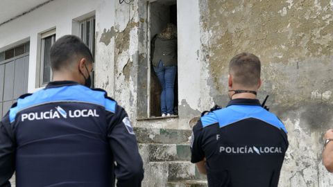 Unos polic�as locales, frente a la casa donde viv�a la mujer en situaci�n precaria