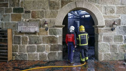 Dos bomberos analizando el estado del interior del inmueble.