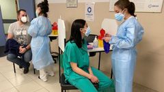 Los enfermeros Sergio �lvarez L�pez y Aida Bouza Torres, ambos de la planta covid, reciben la primera dosis de la vacuna contra el coronavirus dentro de la campa�a para sanitarios del �rea Sanitaria de Ferrol, en primer t�rmino otra enfermera, Jessica Seco, administra la dosis