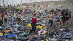 Decenas de inmigrantes en la playa de Ceuta tras cruzar la frontera por el mar ayudados por flotadores.