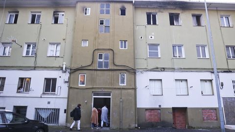 Vecinos accediendo al portal del piso que se incendi�, envueltos en mantas.