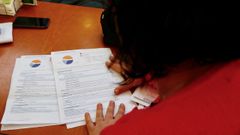 Una mujer revisa la factura de la luz de sus padres, perceptores del bono social.