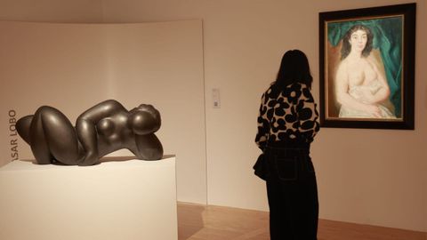 Una visitante observa un desnudo femenino de Manuel Colmeiro; detr�s, �� la source� (1989), escultura de mujer en yeso de Baltasar Lobo.